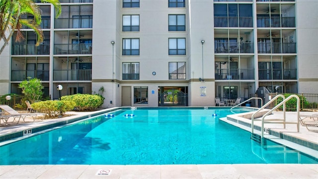 community pool with ceiling fan and a patio area