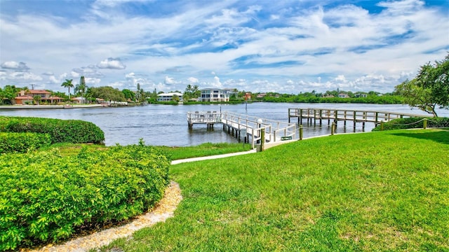 view of dock with a water view and a lawn