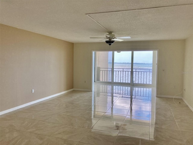 6430 Sun Eagle Ln Unit 203, Bradenton, FL 34210 - unfurnished room featuring baseboards, a ceiling fan, light tile patterned floors, a textured ceiling, and a water view