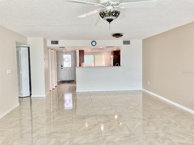 6430 Sun Eagle Ln Unit 203, Bradenton, FL 34210 - spare room with a ceiling fan, a textured ceiling, light marble finish flooring, and baseboards