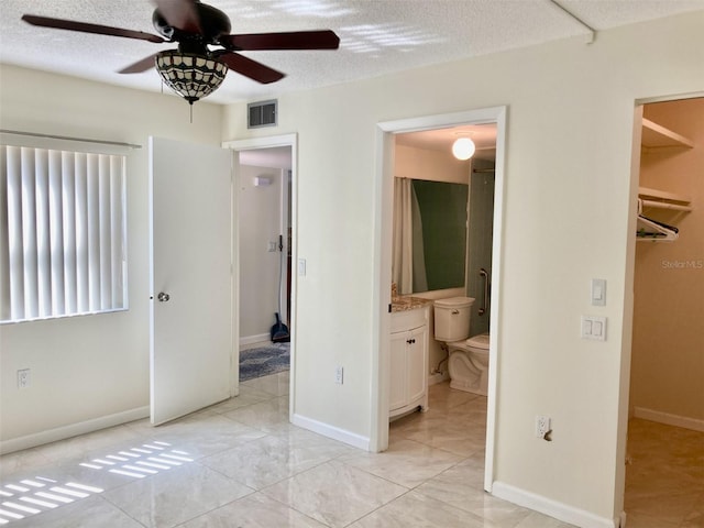 6430 Sun Eagle Ln Unit 203, Bradenton, FL 34210 - unfurnished bedroom with ensuite bath, a textured ceiling, a ceiling fan, and baseboards
