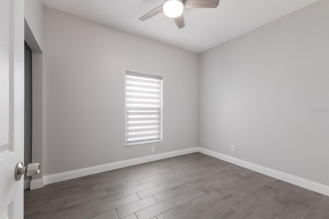 empty room with a ceiling fan, wood finished floors, and baseboards