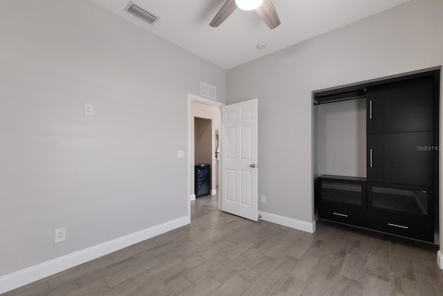 unfurnished bedroom featuring wood finished floors, baseboards, a ceiling fan, and a closet