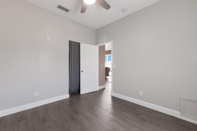 empty room with a ceiling fan, dark wood-style floors, and baseboards