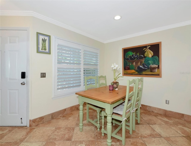 dining room featuring baseboards, crown molding, and stone tile floors