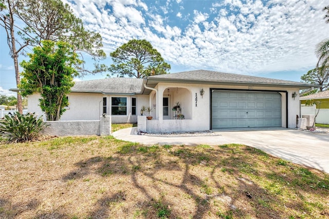 single story home with stucco siding, driveway, and a garage