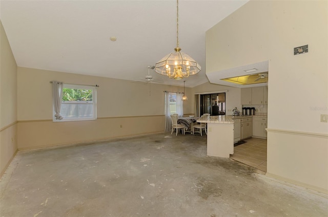unfurnished dining area featuring a chandelier, concrete floors, ceiling fan, and lofted ceiling
