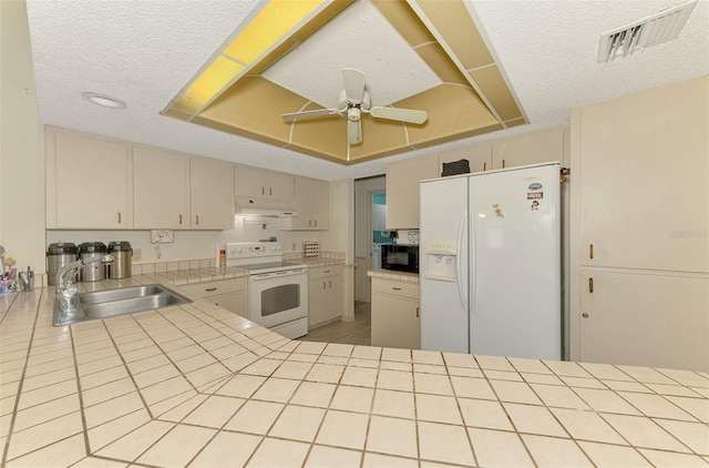 kitchen featuring white appliances, a sink, under cabinet range hood, tile counters, and ceiling fan