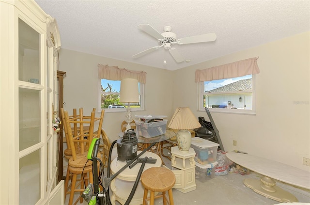 miscellaneous room with concrete floors, a textured ceiling, and a ceiling fan
