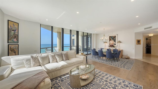 1241 Gulf Of Mexico Dr Unit 803, Longboat Key, FL 34228 - living area featuring a chandelier, hardwood / wood-style floors, a water view, recessed lighting, and floor to ceiling windows