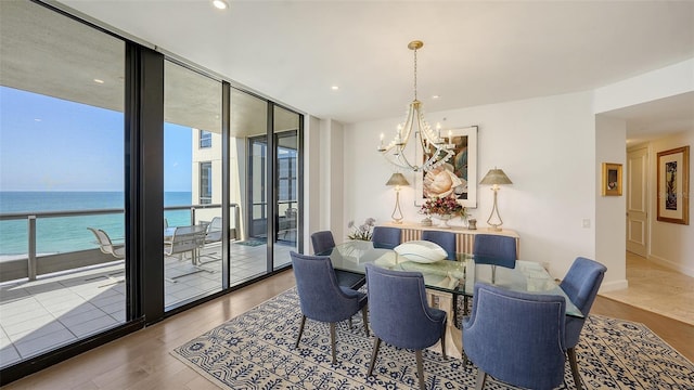 1241 Gulf Of Mexico Dr Unit 803, Longboat Key, FL 34228 - dining room with a chandelier, wood finished floors, floor to ceiling windows, a water view, and recessed lighting