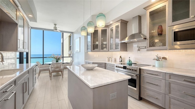 1241 Gulf Of Mexico Dr Unit 803, Longboat Key, FL 34228 - kitchen featuring stainless steel appliances, wall chimney range hood, gray cabinets, a sink, and a center island