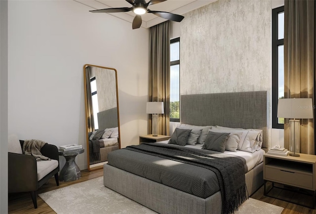 bedroom featuring a ceiling fan, a towering ceiling, and wood finished floors