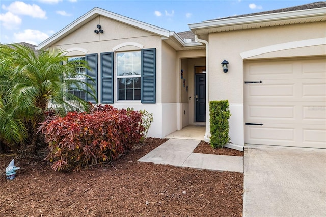 doorway to property with stucco siding and a garage