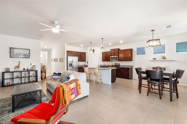 living area featuring light tile patterned floors, a ceiling fan, and recessed lighting