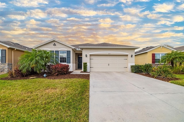 ranch-style home with an attached garage, stucco siding, driveway, and a yard