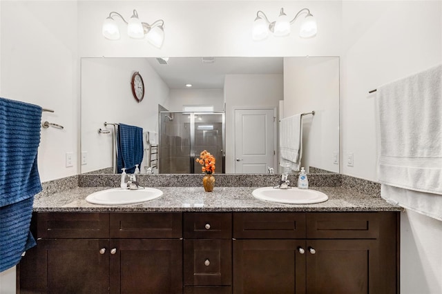 bathroom featuring a stall shower and double vanity