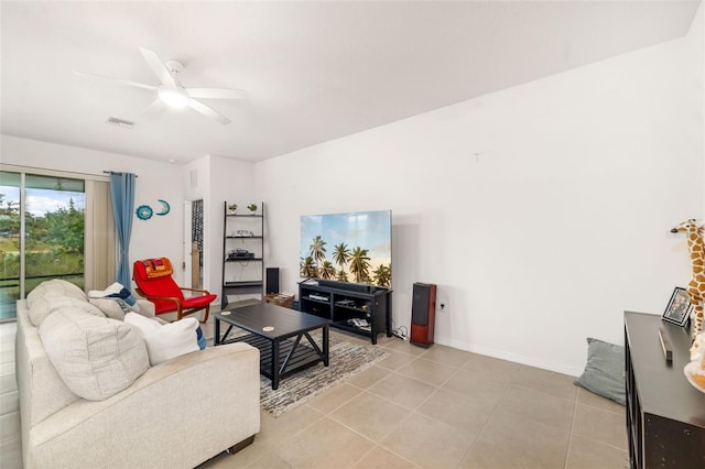 living room with ceiling fan, light tile patterned floors, and baseboards