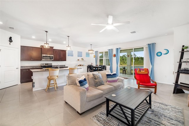 living area featuring light tile patterned flooring, ceiling fan, and recessed lighting