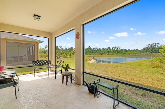 sunroom featuring a water view