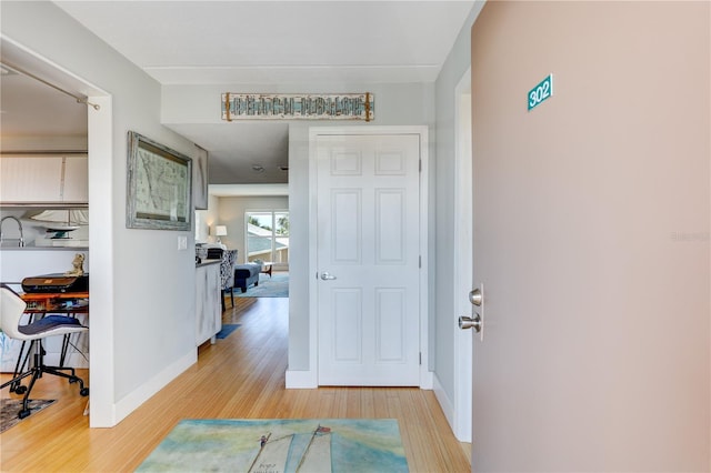 foyer entrance with light wood-type flooring and baseboards