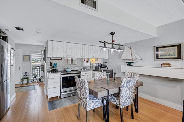 dining area with light wood finished floors and baseboards