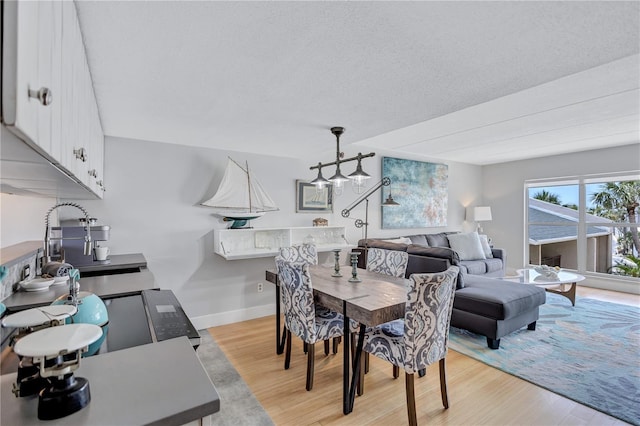 dining space featuring light wood finished floors and baseboards