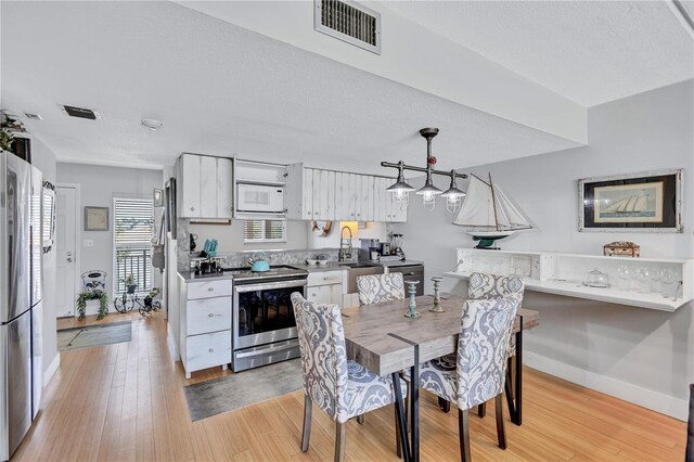 dining area featuring light wood-style floors and baseboards