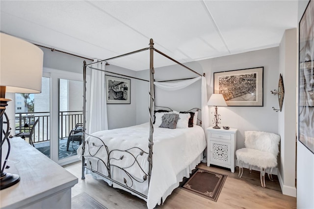 bedroom with access to exterior and light wood-type flooring