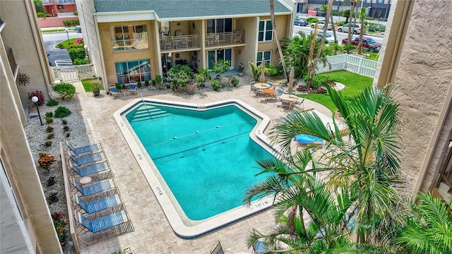 community pool with a patio and fence