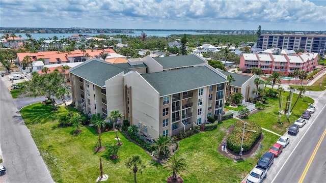 drone / aerial view of a nearby body of water and apartment complex / building