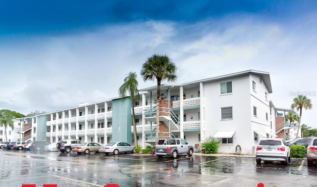 view of building exterior featuring uncovered parking and stairway