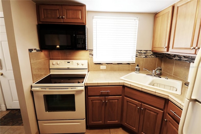 kitchen with a sink, electric stove, backsplash, light tile patterned flooring, and black microwave