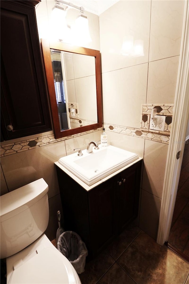 half bath with tile patterned floors, tile walls, toilet, and vanity