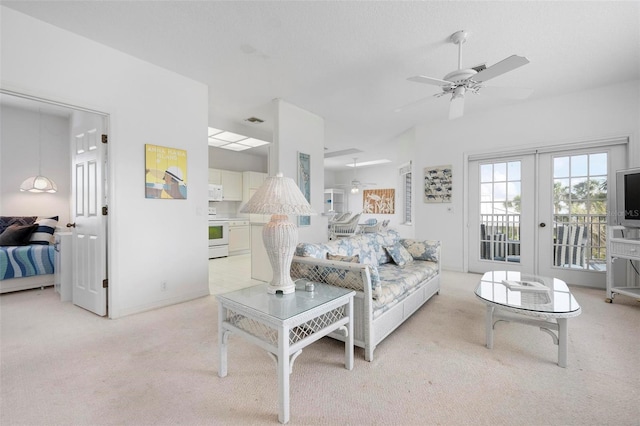 living room featuring light carpet, a ceiling fan, and french doors