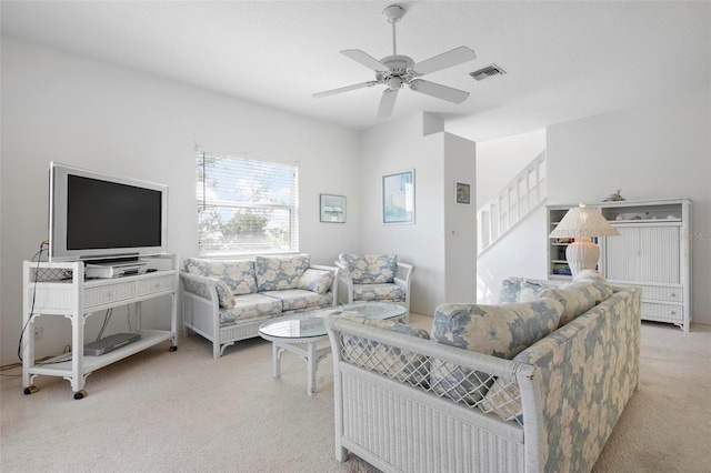 carpeted living room with stairway and a ceiling fan
