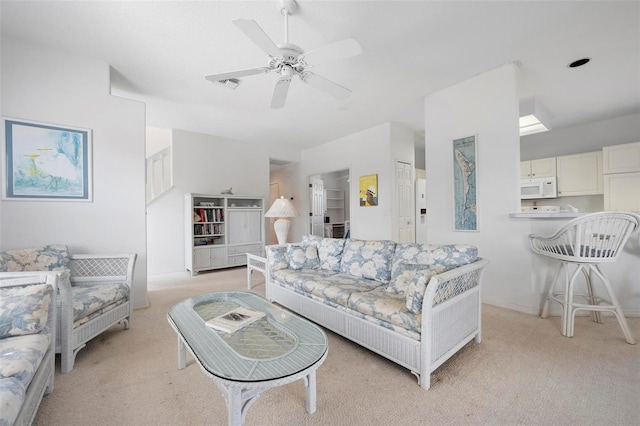 living area with light carpet and ceiling fan