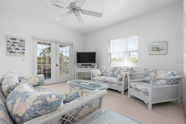 carpeted living area featuring french doors and ceiling fan