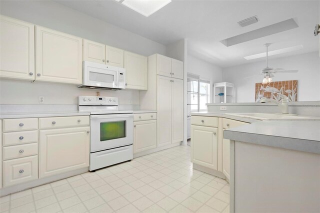 kitchen with white appliances, light countertops, white cabinetry, and a ceiling fan