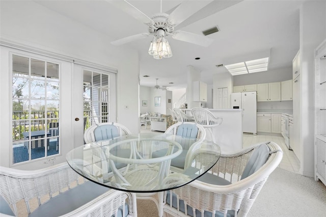 dining space featuring ceiling fan and light carpet