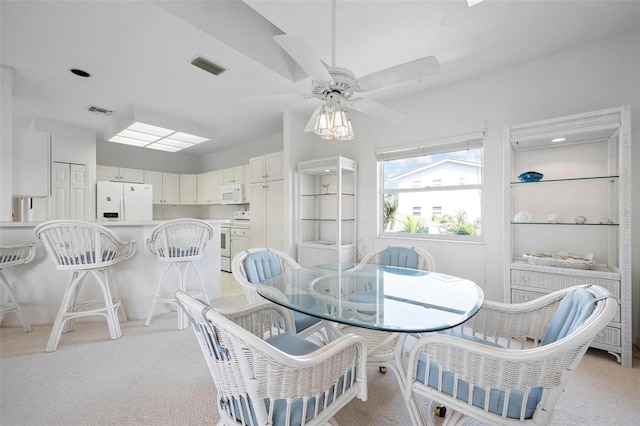 dining area featuring light colored carpet and ceiling fan