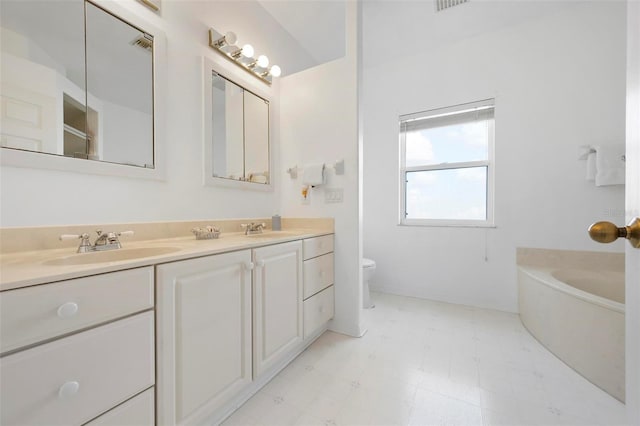 bathroom featuring toilet, double vanity, a bath, and tile patterned floors