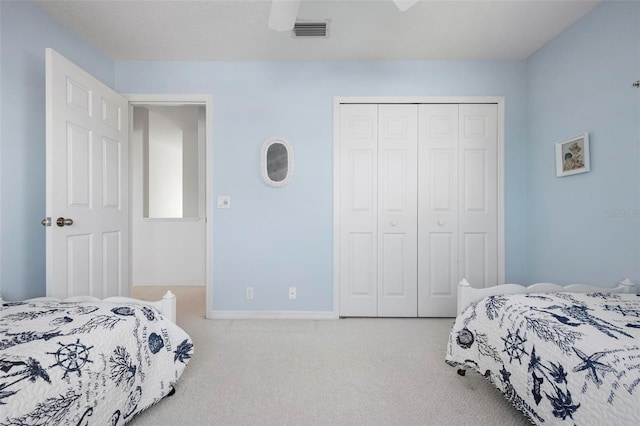carpeted bedroom with a closet, baseboards, and a ceiling fan