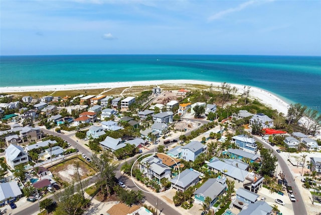aerial view of property and surrounding area featuring expansive coastline and nearby suburban area