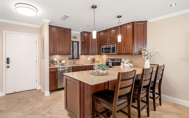 kitchen featuring light tile patterned floors, a sink, a peninsula, tasteful backsplash, and appliances with stainless steel finishes