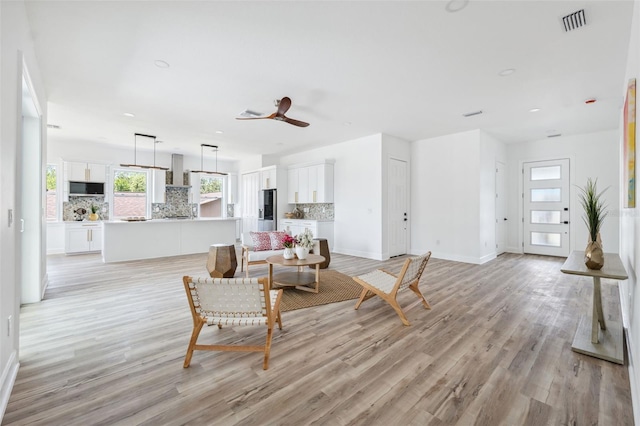 8622 Inwood Dr, Hudson, FL 34667 - living area with light wood finished floors, baseboards, ceiling fan, and visible vents