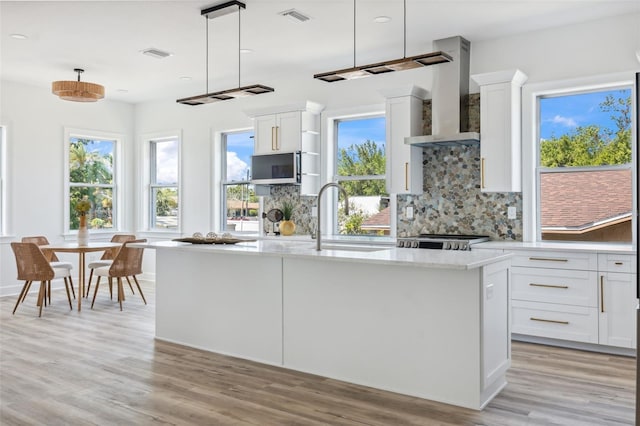 8622 Inwood Dr, Hudson, FL 34667 - kitchen with visible vents, wall chimney range hood, light wood-style floors, stainless steel appliances, and tasteful backsplash