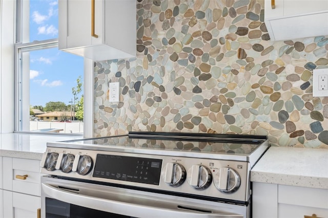 8622 Inwood Dr, Hudson, FL 34667 - details with white cabinetry, stainless steel electric range oven, light stone countertops, and decorative backsplash