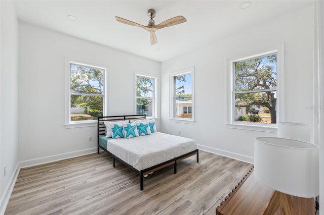 8622 Inwood Dr, Hudson, FL 34667 - bedroom with multiple windows, light wood-style floors, baseboards, and a ceiling fan