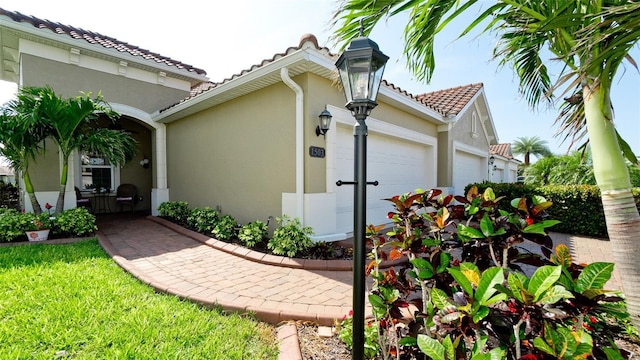 1503 Calle Grand St, Bradenton, FL 34209 - view of property exterior featuring stucco siding, an attached garage, and a tiled roof